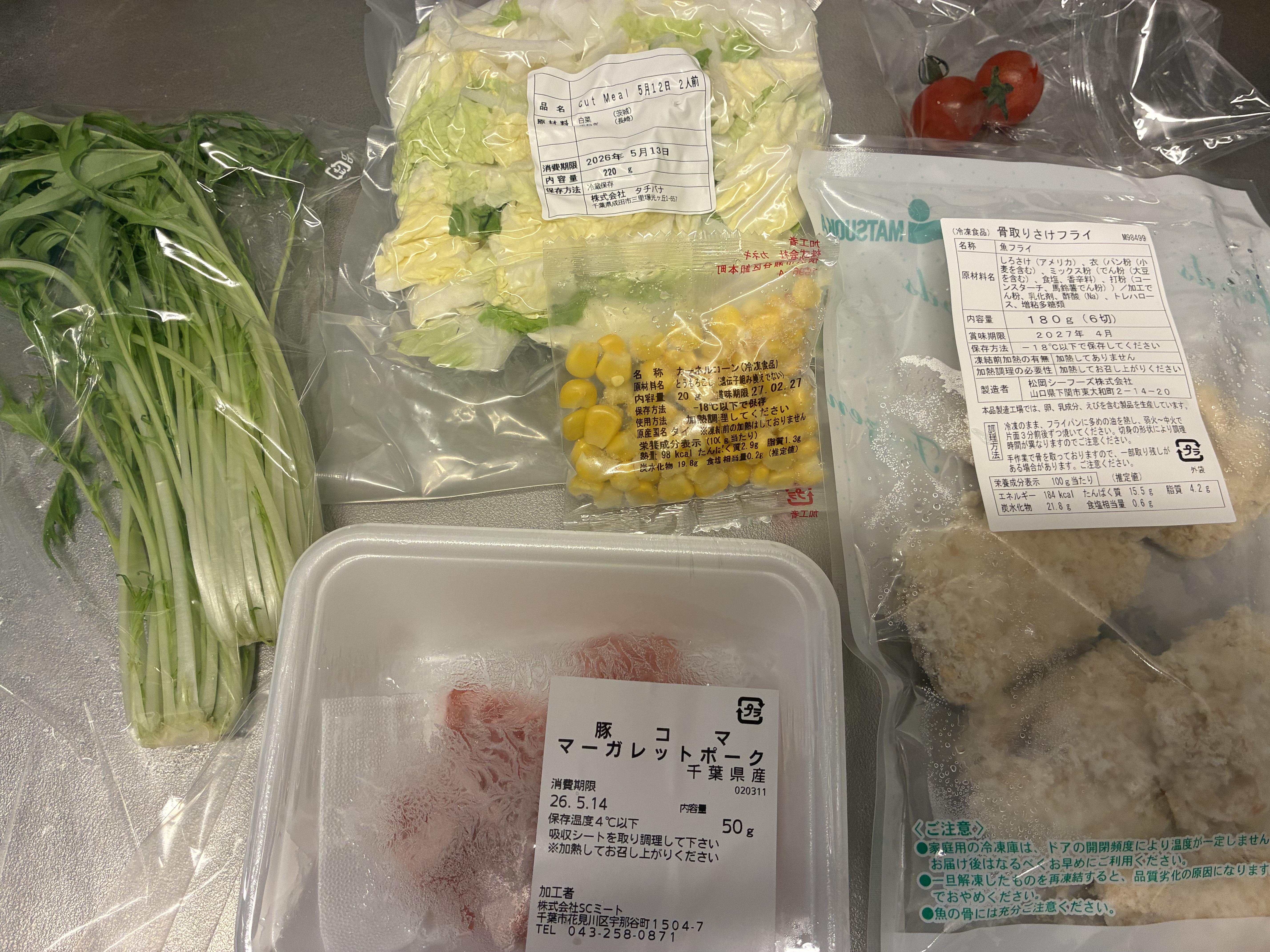 届いた食材一覧。水菜・コーン・白菜・さけのフライ・豚コマなど